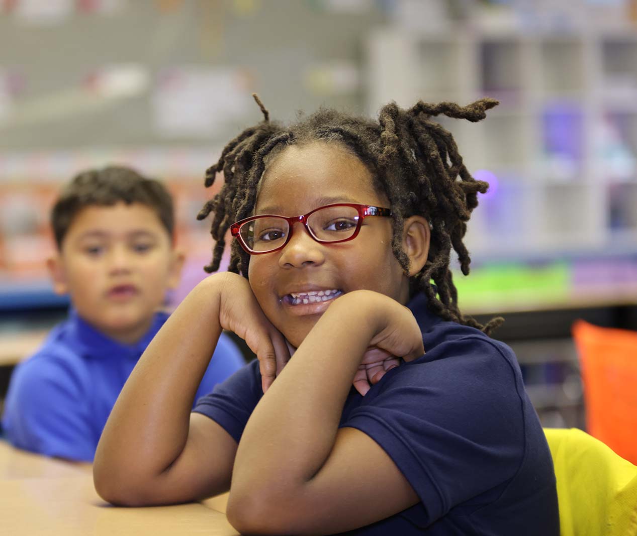 Student working on a notebook in a classroom.